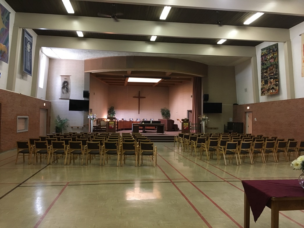 Auditorium with chairs, a cross on the far wall